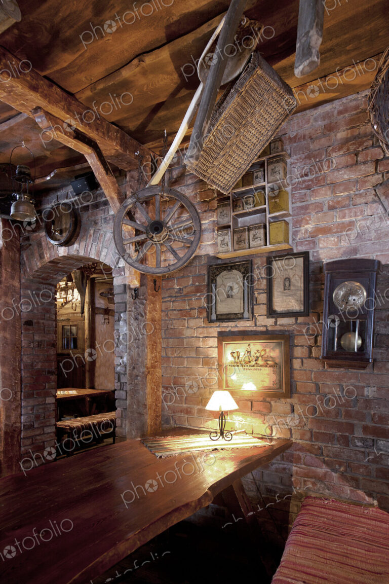 Bar with exposed brickwork and cart wheel, basket and old photographs at night