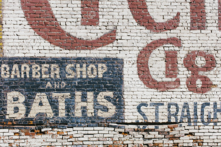 "Barber Shop & Baths" sign painted on old old brick wall