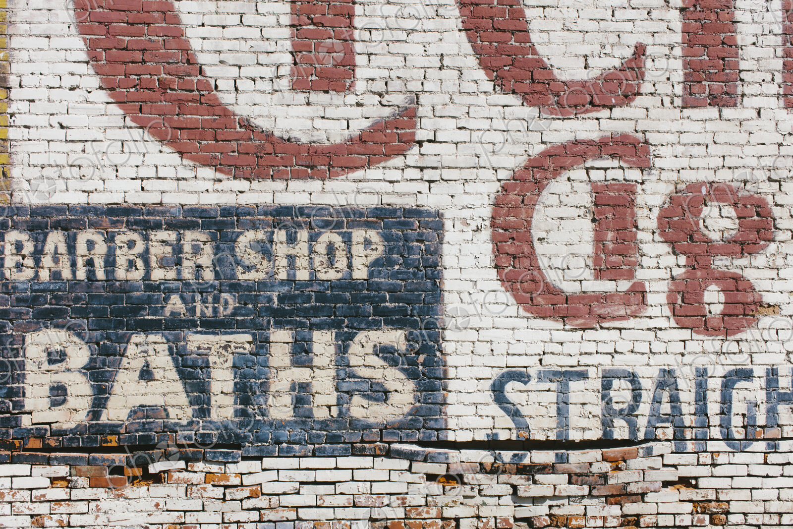 “Barber Shop & Baths” sign painted on old old brick wall