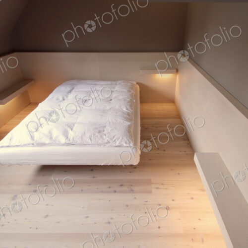 Bare mattress and empty shelves in modern bedroom