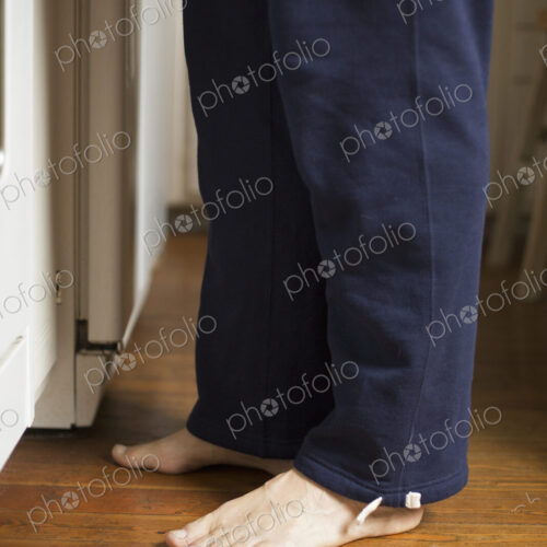 Barefoot man standing in a kitchen.