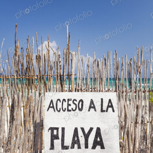 Beach access sign in Spanish,on a fence by the beach Beach access sign in Spanish,on a fence by the beach