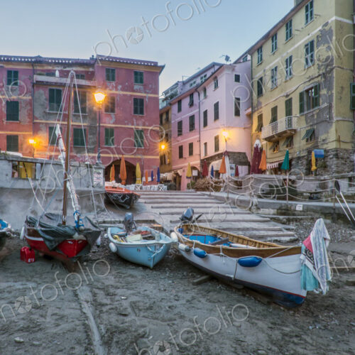Beach and fishing boats on the shore at Le Spezia, a piazza and historic buildings, dawn