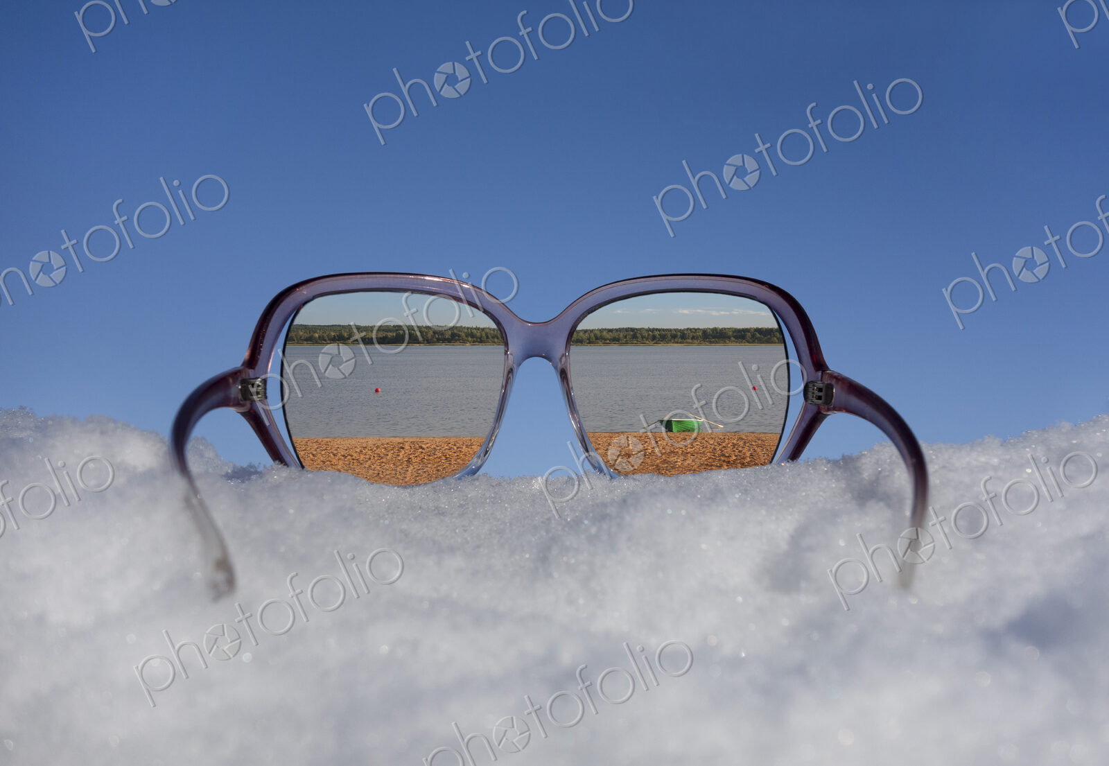 Beach and lakeside seen in reflection in sunglasses on thick snow.