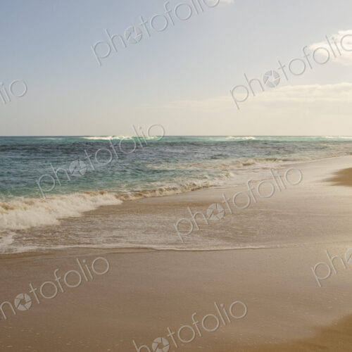 Beach and surf along Oahu's wild North Shore with waves breaking far from the shore. Beach and surf along Oahu's wild North Shore with waves breaking far from the shore.