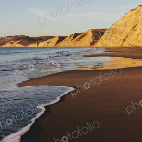 Beach at dawn, with sheer cliffs and rocks. Beach at dawn, with sheer cliffs and rocks.