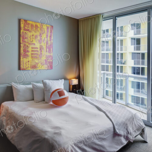 Beach ball on bed in hotel room