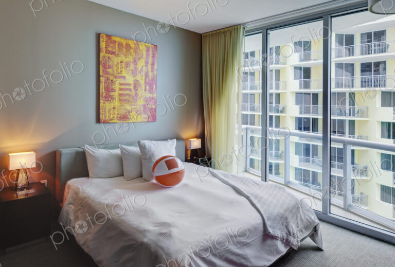 Beach ball on bed in hotel room