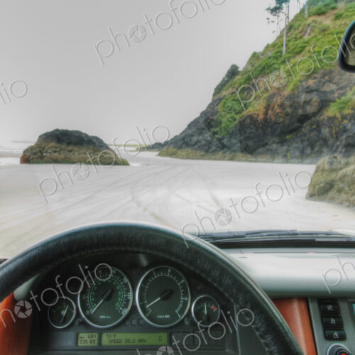 Beach seen from driver's seat of a car, with steering wheel in foreground. Beach seen from driver's seat of a car, with steering wheel in foreground.