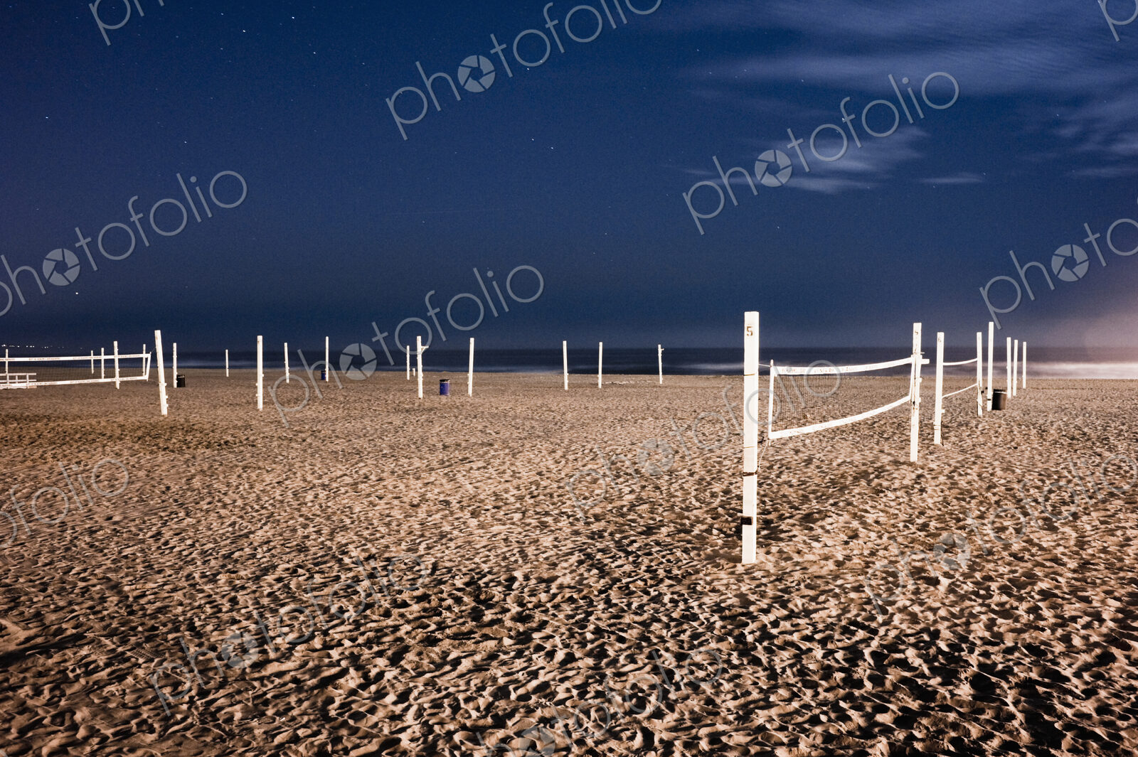 Beach volleyball nets on sand on beach.