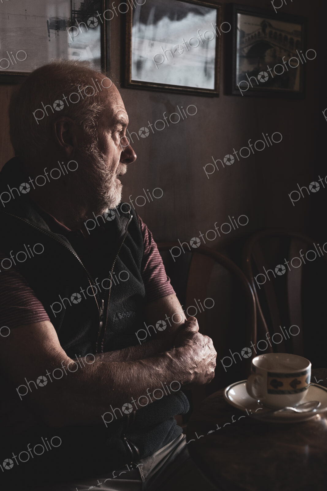 Bearded man sitting at a table with cup of coffee in a cafe.