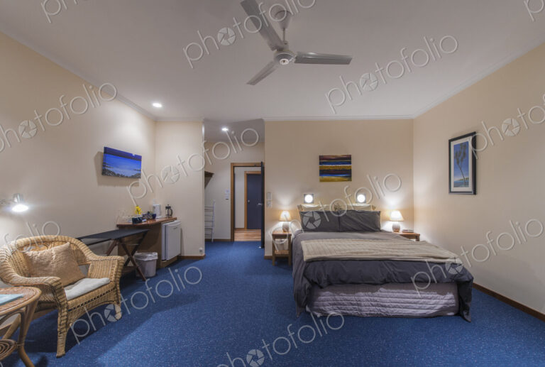 Bed and armchair in hotel room