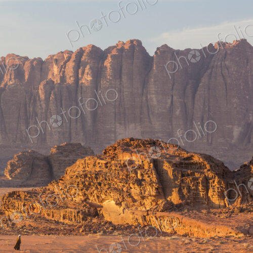 Bedouin walking through desert landscape with rocks and mountains. Bedouin walking through desert landscape with rocks and mountains.