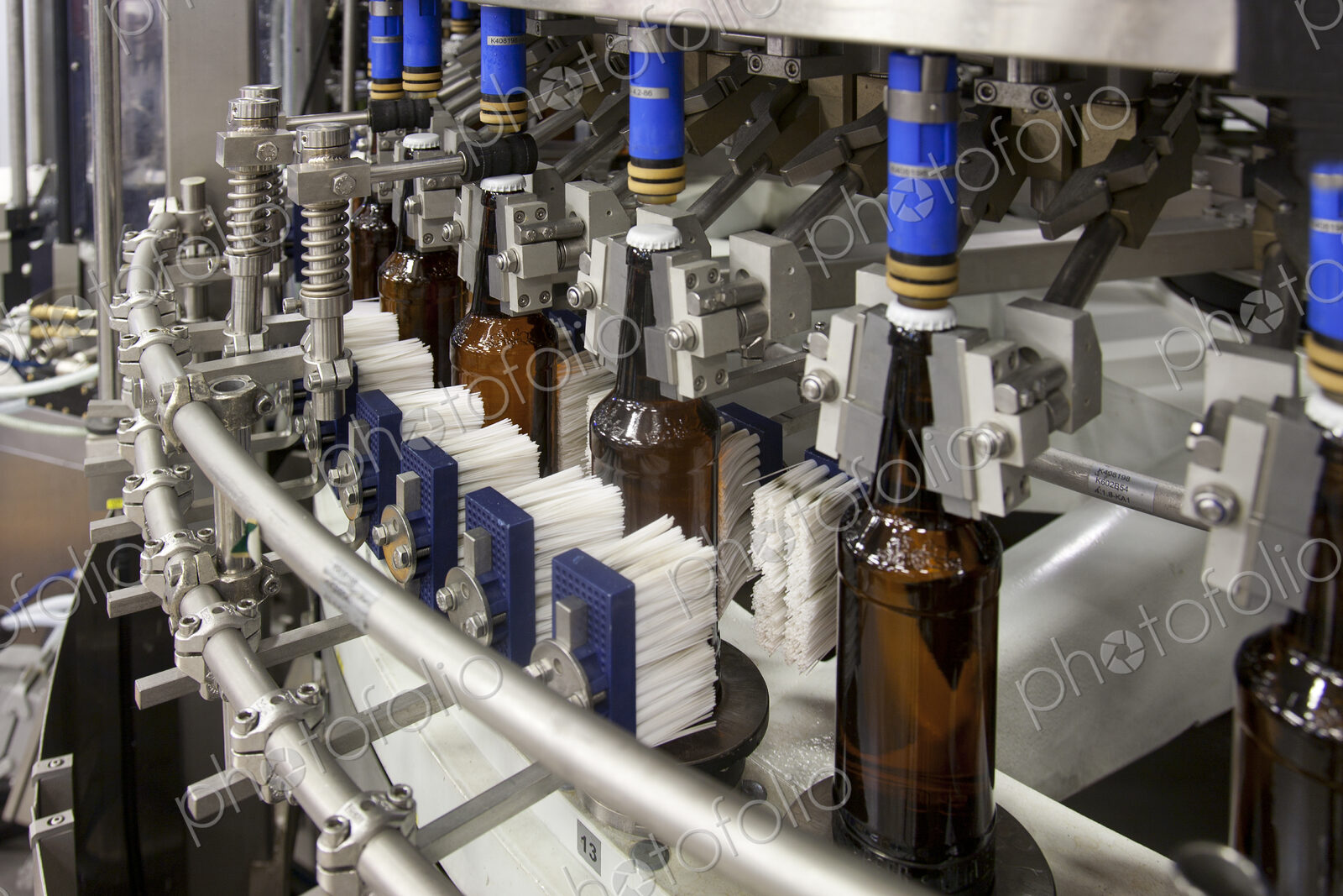 Beer bottling plant with moving belts, rows of bottles, automated process, capping and…