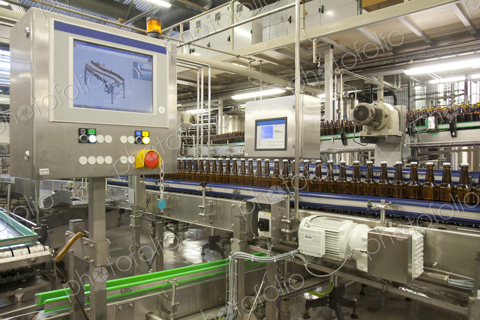 Beer bottling plant with moving belts, rows of bottles, automated process, capping and…