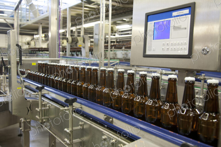 Beer bottling plant with moving belts, rows of bottles, automated process, capping and…
