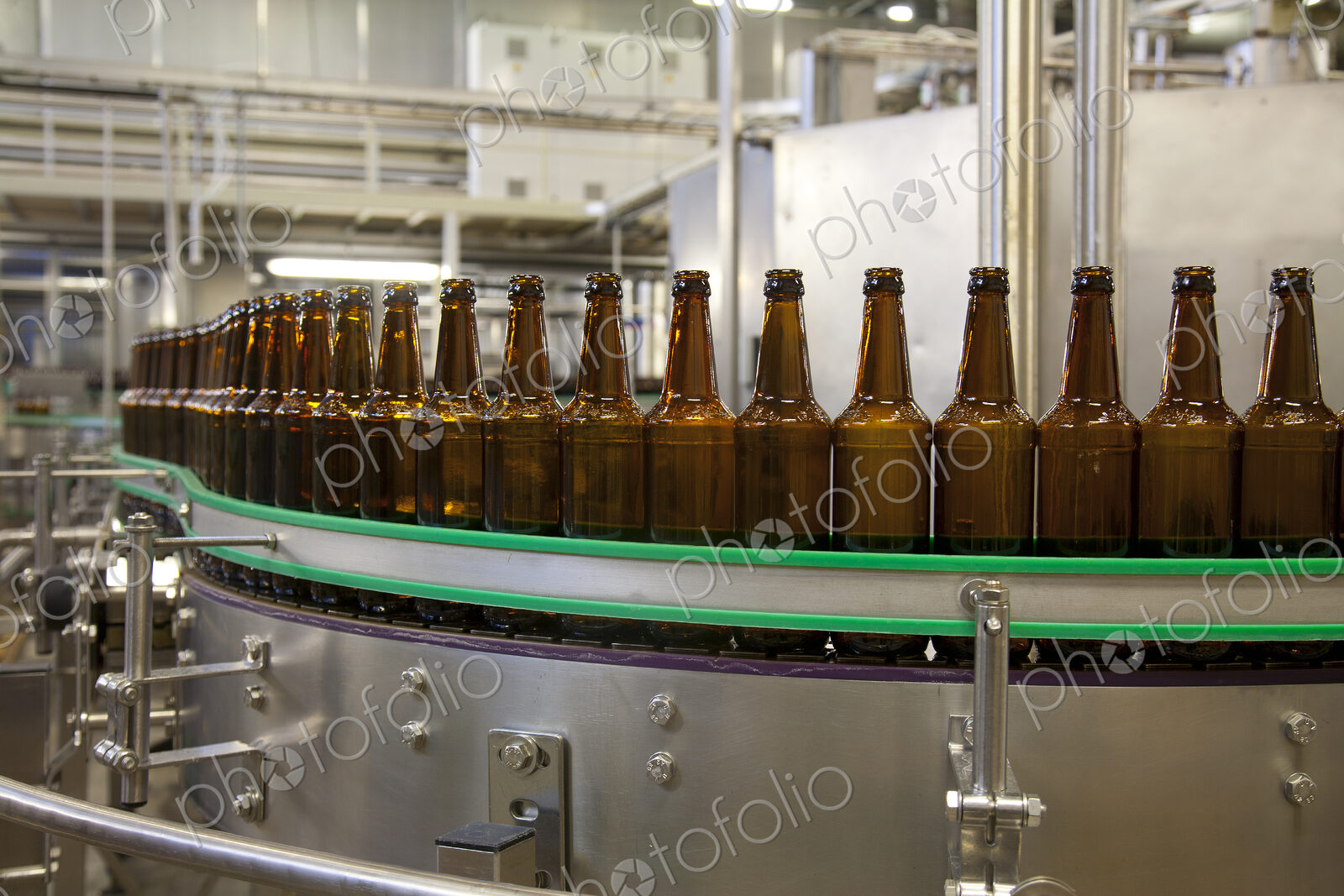Beer bottling plant with moving belts, rows of bottles, automated process, capping and…