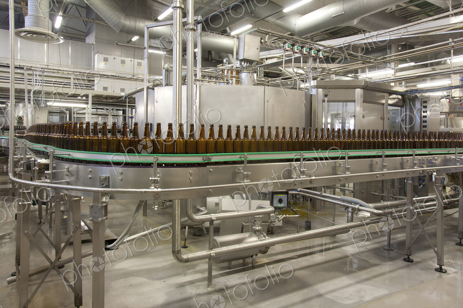 Beer bottling plant with moving belts, rows of bottles, automated process, capping and…