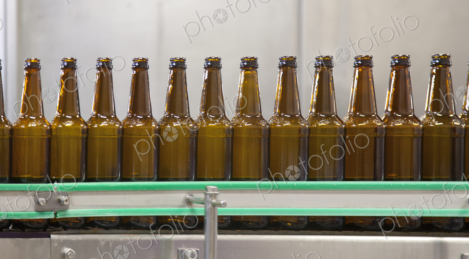 Beer bottling plant with moving belts, rows of bottles, automated process, capping and…