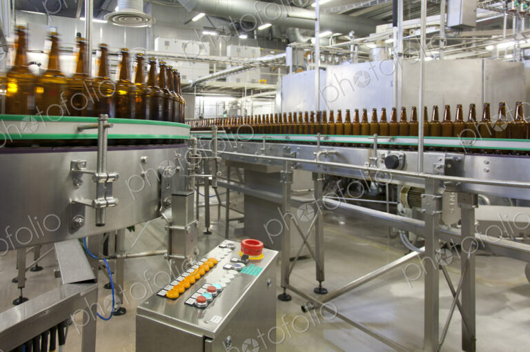 Beer bottling plant with moving belts, rows of bottles, automated process, capping and…