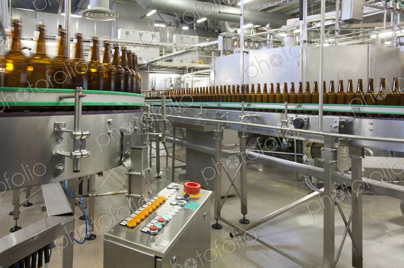 Beer bottling plant with moving belts, rows of bottles, automated process, capping and…