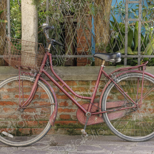 Bicycle leaning against wall.
