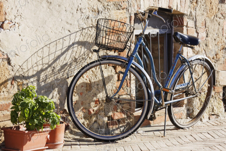 Bicycle leaning on stone house wall.
