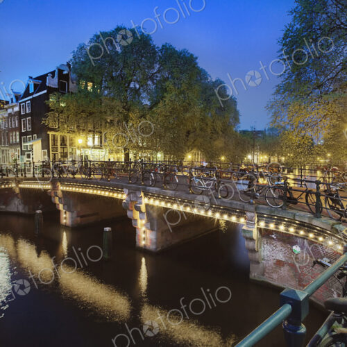 Bicycles Parked on Bridge Over Canal