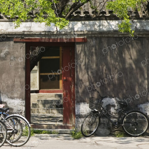 Bicycles leaning against exterior wall of house courtyard. Bicycles leaning against exterior wall of house courtyard.
