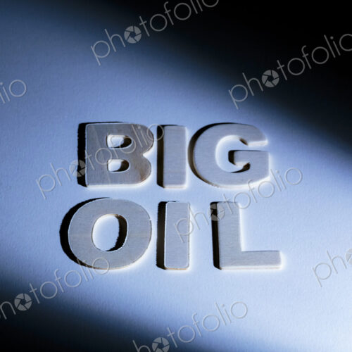 Big Oil sign, lettering on a blue surface, shadows, studio shot