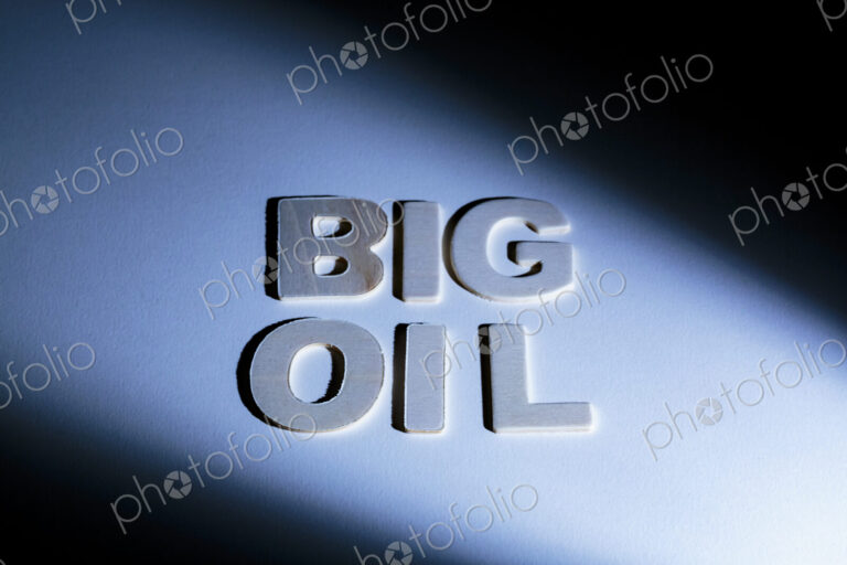 Big Oil sign, lettering on a blue surface, shadows, studio shot
