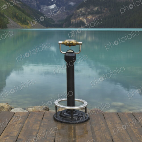 Binoculars overlooking still lake in rural landscape Binoculars overlooking still lake in rural landscape