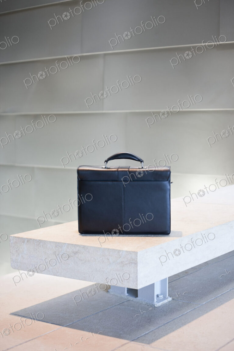 Black Briefcase on White Stone Bench