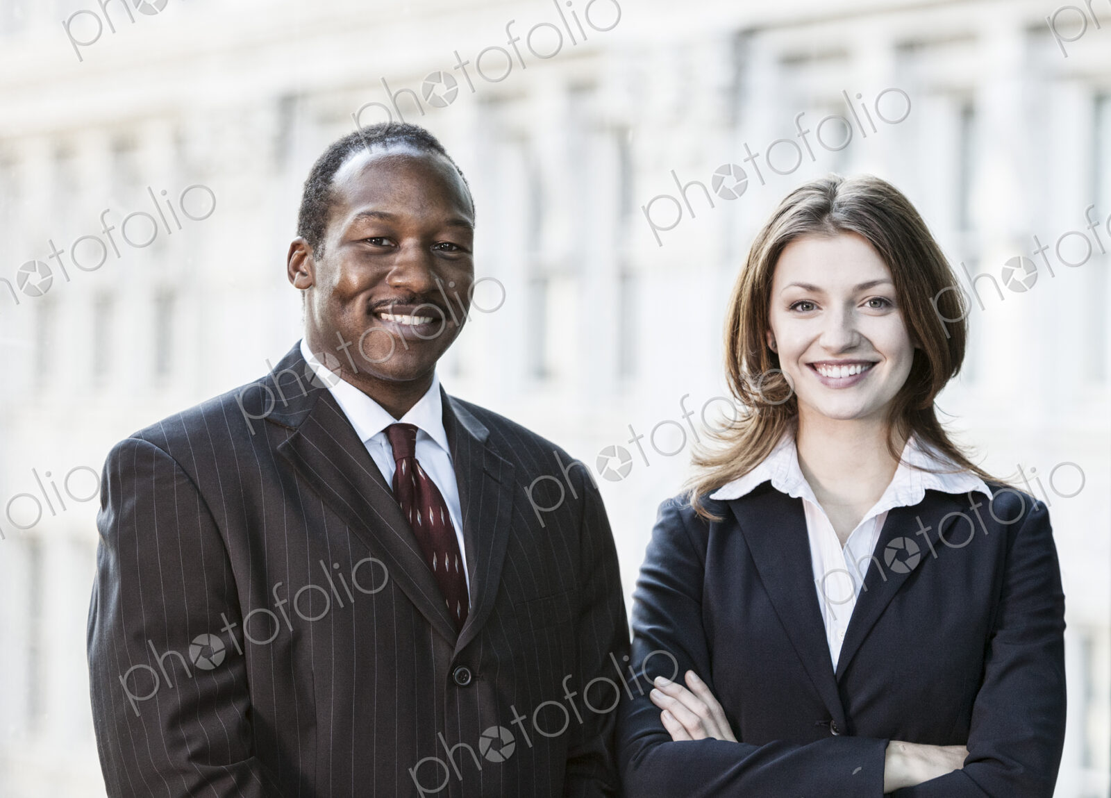 Black business man and caucasian business woman together in front of an older office…