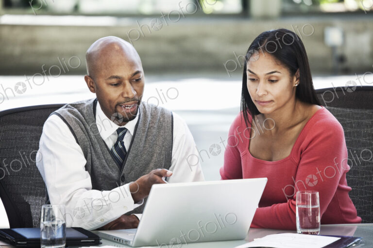Black business man and mixed race caucasian woman in a business center meeting.