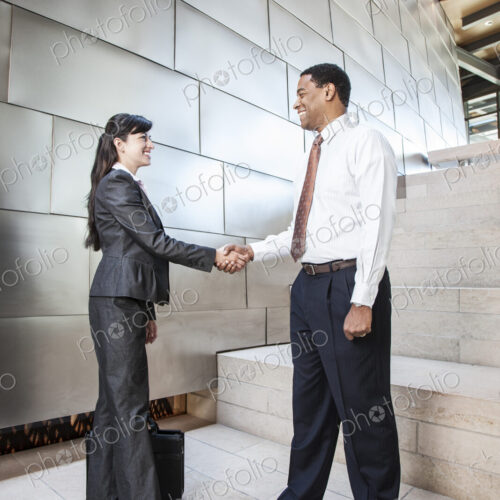 Black businessman and Hispanic businesswoman in a business premises, warehouse,…