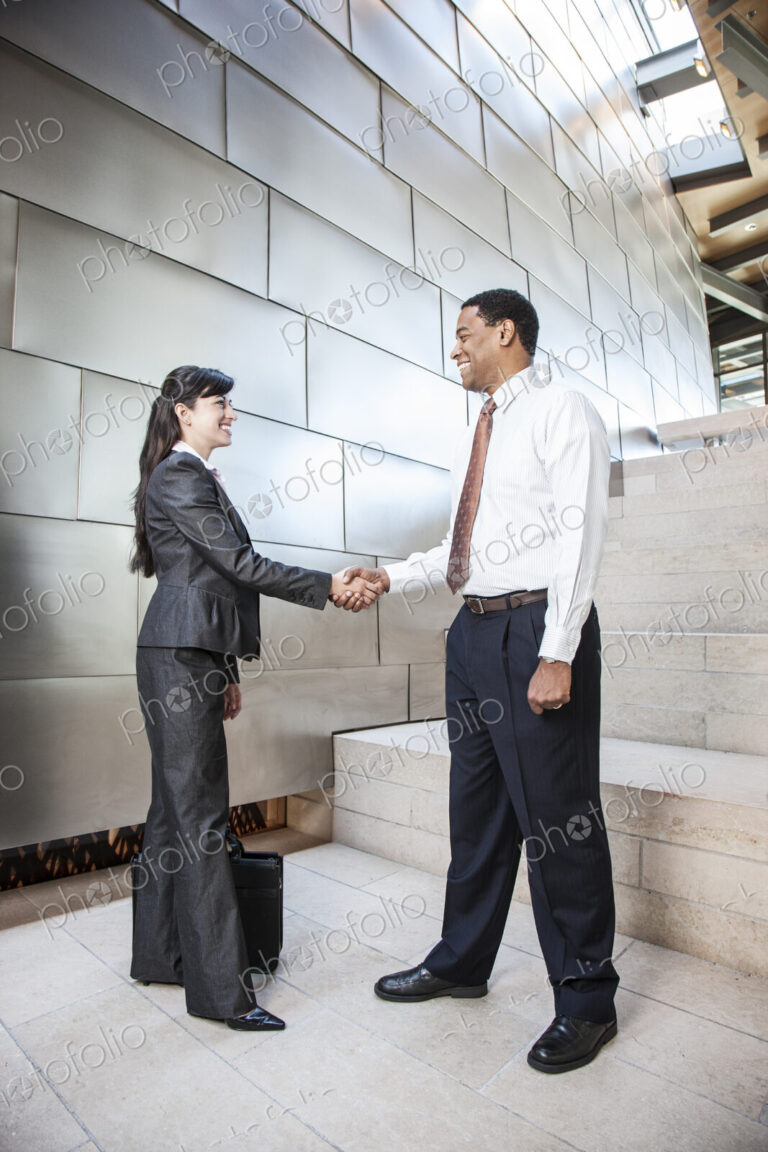 Black businessman and Hispanic businesswoman in a business premises, warehouse,…