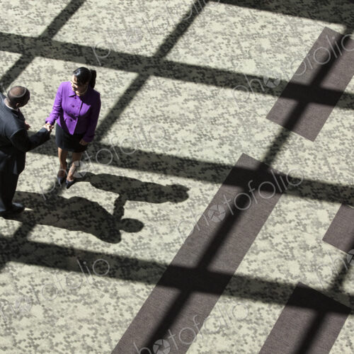 Black businessman and woman meeting in the lobby of a large business center. Black businessman and woman meeting in the lobby of a large business center.