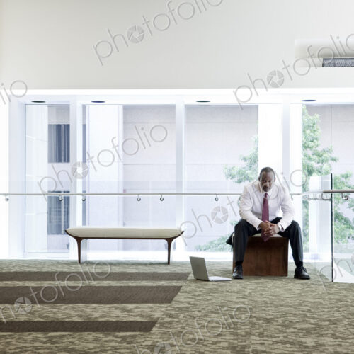 Black businessman in lobby of large business center. Black businessman in lobby of large business center.