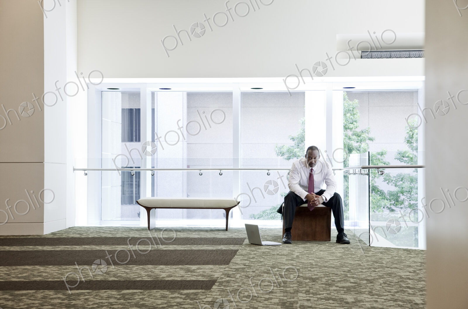Black businessman in lobby of large business center.