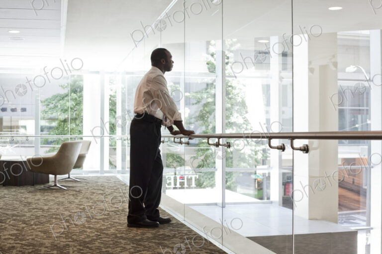 Black businessman in lobby of large business center.