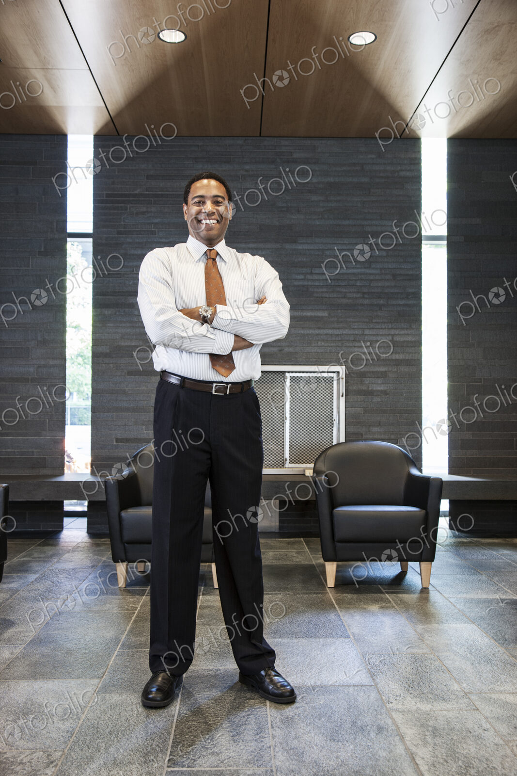 Black businessman in the lobby of a large office building.