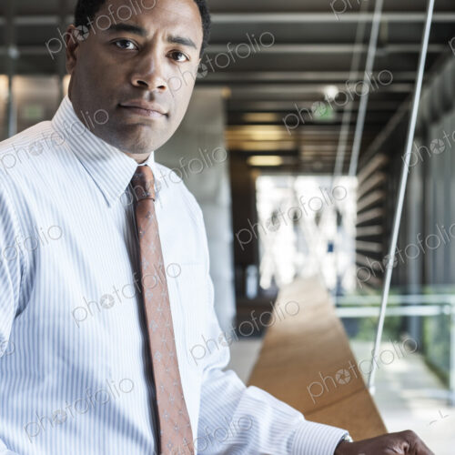 Black businessman in the lobby of a large office building. Black businessman in the lobby of a large office building.