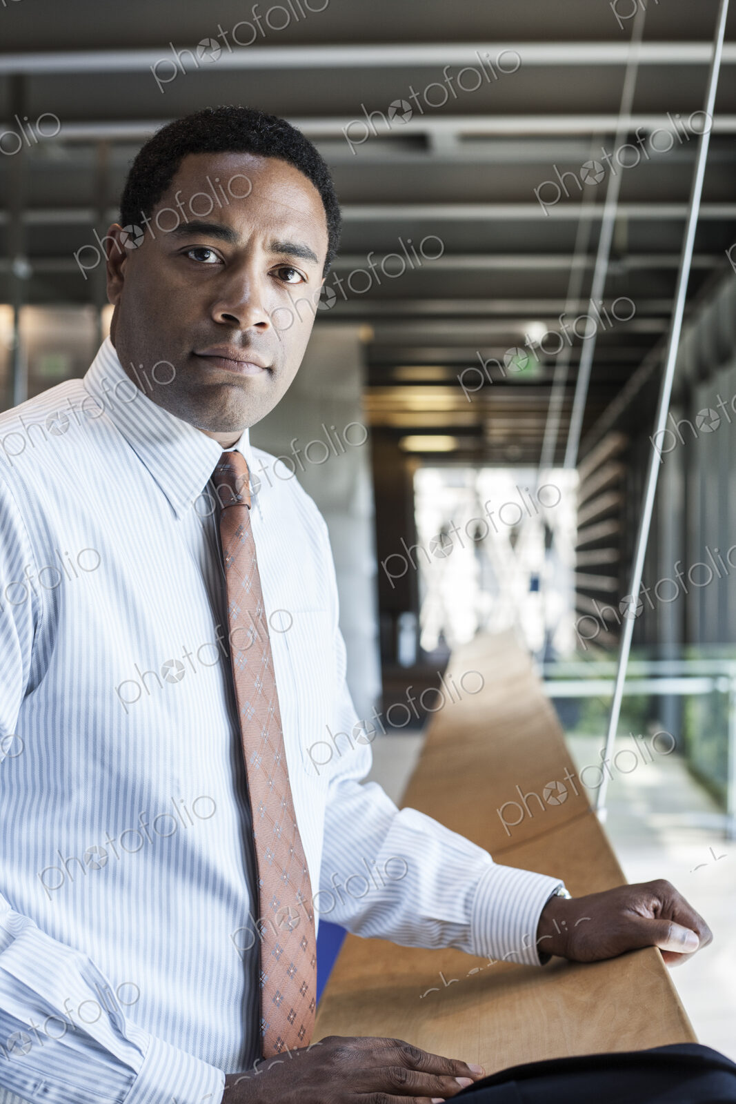 Black businessman in the lobby of a large office building.