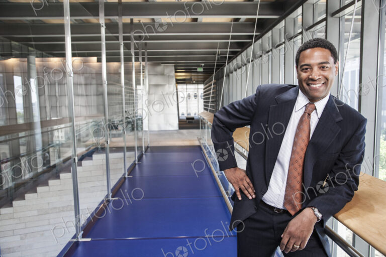 Black businessman in the lobby of a large office building.