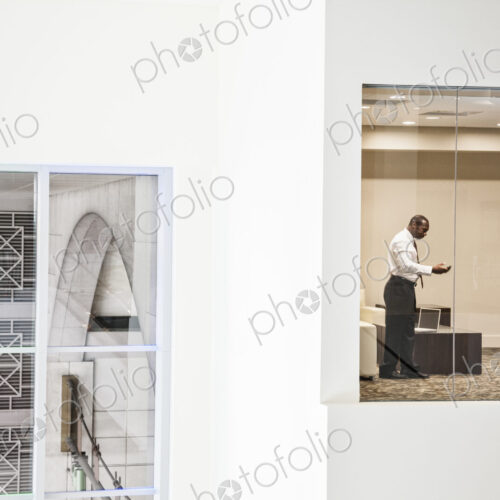 Black businessman working on a computer in a business center conference room.