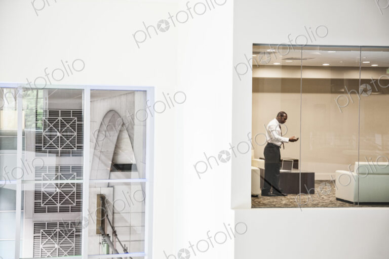 Black businessman working on a computer in a business center conference room.