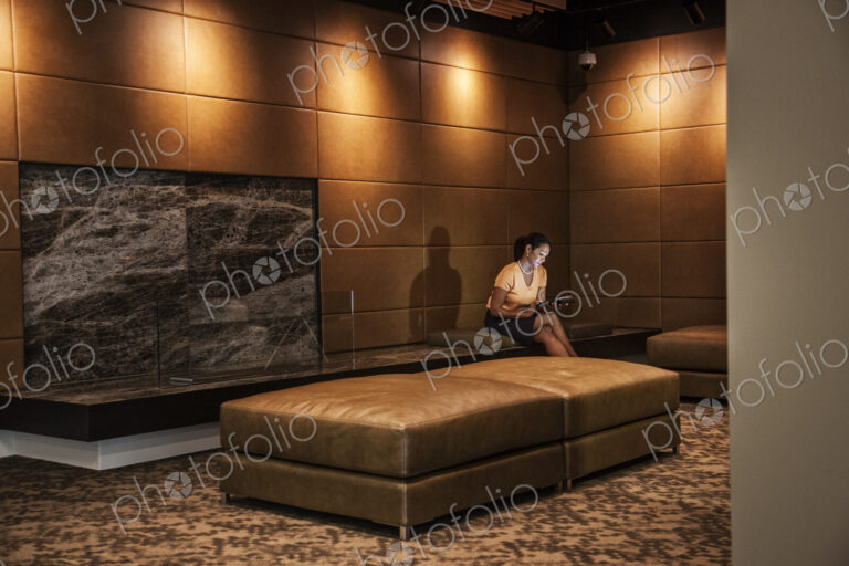 Black businesswoman working on a computer in a hotel lobby.