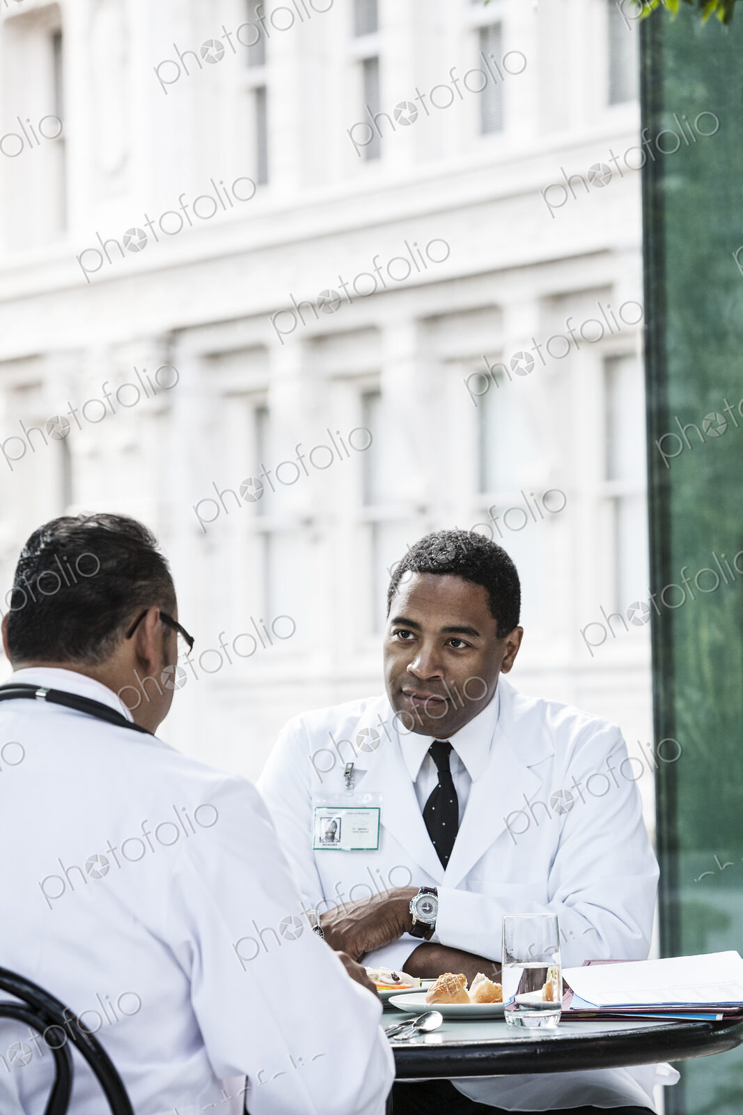Black man doctor in a lunch time discussion with a colleague.