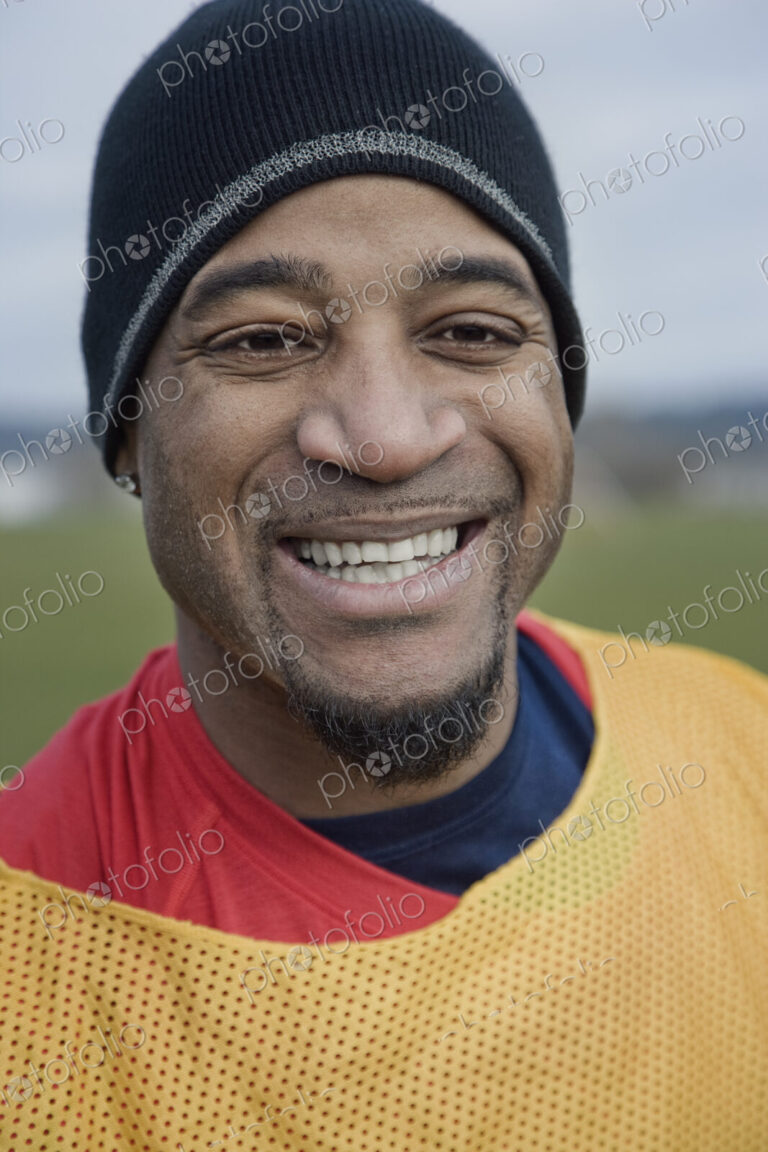 Black man in sports vest and woolly hat, member of a weekend sports team in the winter.